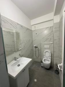 a white bathroom with a sink and a toilet at Evita's House in Lukovë