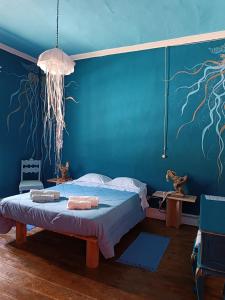 a bedroom with a bed and a blue wall with tentacles at Avó da Rosa 2 in Faial da Terra