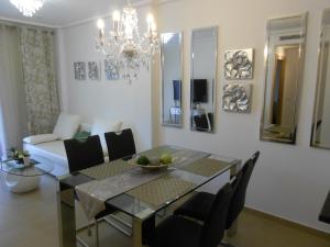 een eetkamer en woonkamer met een tafel en stoelen bij Jardinas de les Marinas in Denia