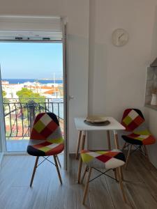 a room with two chairs and a table and a balcony at "Calm Joy & J" - Infinity in Ermoupoli