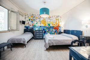 a bedroom with two beds and a colorful wall at Villa Scilla e Cariddi in Messina