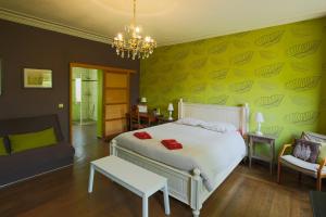 a bedroom with a white bed and a green wall at Aubépine in Sains-du-Nord