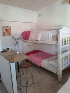 a room with two bunk beds and a table at Departamentos la cascada in Termas de Río Hondo