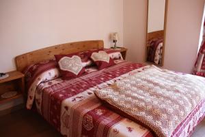 a bed with red and white blankets and pillows at Lo Trapei in Aosta