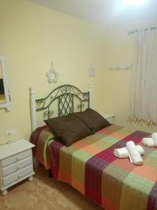 sypialnia z łóżkiem z kolorowym kocem i stolikiem nocnym w obiekcie Relájate en pareja o familia!!! w mieście Tavernes de Valldigna