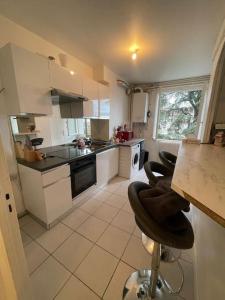 een keuken met witte kasten en zwarte apparaten bij Appartement 2 chambres parking draps et serviettes non fournies in Agen