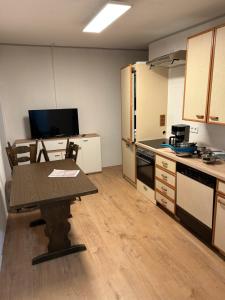 een keuken met een houten tafel en een tableasteryasteryasteryasteryasteryasteryasteryasteryasteryastery bij Ferienwohnung Kotsch in Engen