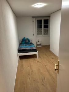 een slaapkamer met een bed in een kamer met een houten vloer bij Ferienwohnung Kotsch in Engen