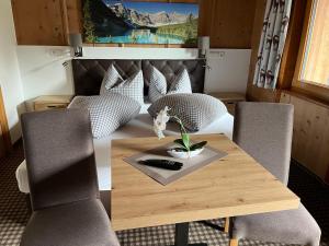Cette chambre comprend une table en bois avec des chaises et un lit. dans l'établissement Hotel Garni Schönblick, à Sölden