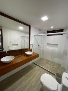 baño con 2 lavabos y ducha de cristal en FLATS SHALON - MORRO DE SÃO PAULO en Cairu