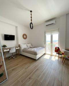 een slaapkamer met een bed, een bureau en een televisie bij "Calm Joy & J" - Infinity in Ermoupoli