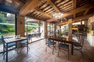 a dining room with tables and chairs and windows at La Maestà antica dimora di campagna in Foligno