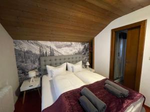 考訥塔爾的住宿－Apart Sonnenheim，卧室配有一张白色大床,墙上挂有绘画作品