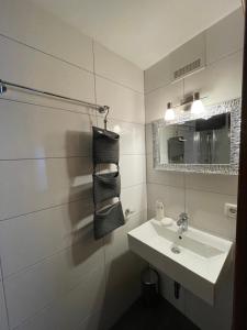 a white bathroom with a sink and a mirror at Apart Sonnenheim in Kaunertal