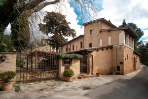 a large brick building with a gate in front of it at La Maestà antica dimora di campagna in Foligno