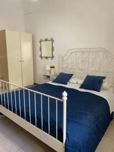 a bedroom with a large bed with blue pillows at Appartamento Azzurra in Lecce