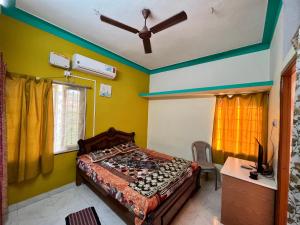 una camera con un letto in una stanza con pareti gialle di Mullai Home Stay a Salem