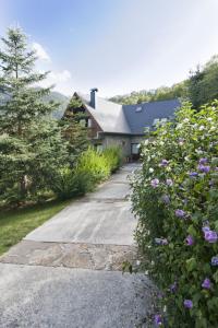 ein Haus mit lila Blumen vor einer Einfahrt in der Unterkunft Casa Lola Pirene in Vielha e Mijaran