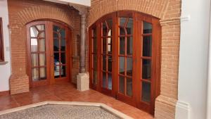 JocotenangoにあるCasa Camilaのレンガの壁の客室内の木製ドア2つ