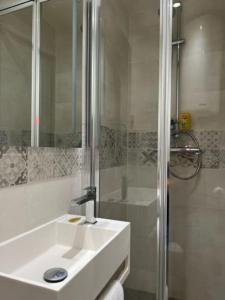 bagno bianco con lavandino e doccia di Studio neuf s/jardin, très calme a Colombes