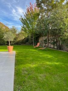 un cortile verde con due panchine in erba di Studio neuf s/jardin, très calme a Colombes