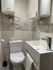bagno con servizi igienici bianchi e lavandino di Studio neuf s/jardin, très calme a Colombes