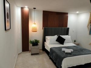 a bedroom with a large bed with a black headboard at Exclusivo Apto lujoso central, sereno y cómodo in Medellín
