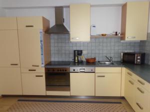 a kitchen with white cabinets and a sink at K3 Ferienhaus in Strobl