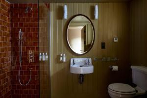 ein Bad mit einem Waschbecken und einem Spiegel in der Unterkunft The George In Rye in Rye