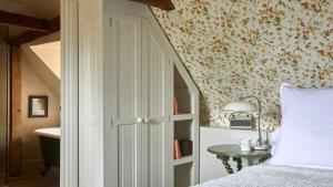 a bedroom with a bed and a wall with flowers at The George In Rye in Rye