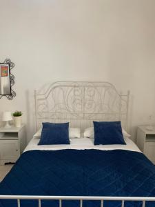 1 dormitorio con cama azul y almohadas azules en Appartamento Azzurra en Lecce
