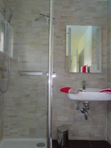 y baño con ducha, lavabo y espejo. en K3 Ferienhaus en Strobl