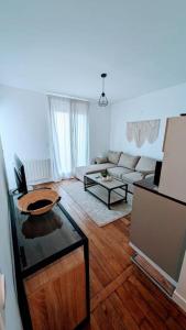 uma sala de estar com um sofá e uma televisão em 2 pièces Cosy avec vue Panoramique et Balcon ! em Rosny-sous-Bois