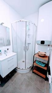 uma casa de banho branca com um chuveiro e um lavatório. em 2 pièces Cosy avec vue Panoramique et Balcon ! em Rosny-sous-Bois
