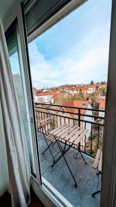 uma varanda com um banco e uma vista a partir de uma janela em 2 pièces Cosy avec vue Panoramique et Balcon ! em Rosny-sous-Bois