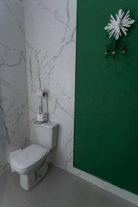 a bathroom with a white toilet and a green door at Casa Fé - Caminhos de Ouro Preto in Ouro Preto