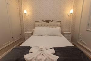 a bedroom with a white bed with a bow on it at Casa Fé - Caminhos de Ouro Preto in Ouro Preto