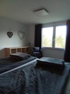 a bedroom with two beds and a window and a chair at Bergblick in Thale