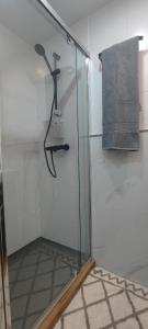 a glass shower stall with a hanger on a wall at Boquerón 5 in Torre del Mar +8 photos
