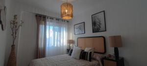 a bedroom with a bed with a mirror and a lamp at Boquerón 5 in Torre del Mar
