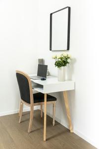 a desk with a laptop and a chair with a mirror at AM3Office apartment with view, Parking and contactless check-in Vevey Montreux in Vevey