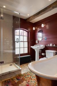 La salle de bains est pourvue d'une baignoire, d'un lavabo et d'une douche. dans l'établissement The George In Rye, à Rye