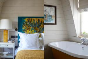 a bedroom with a bed and a tub and a sink at The George In Rye in Rye