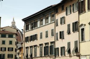 un edificio con ventanas con persianas en una calle de la ciudad en De Cecco Apartments, en Florencia