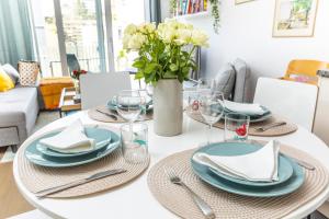 a dining room table with blue plates and a vase of flowers at AM3Office apartment with view, Parking and contactless check-in Vevey Montreux in Vevey