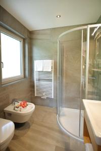 uma casa de banho com um chuveiro, um WC e um lavatório. em Apartments La Mana em Santa Cristina in Val Gardena
