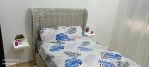 a bed with blue and white sheets and pillows at Luxury Appartement, en plein centre in Kenitra