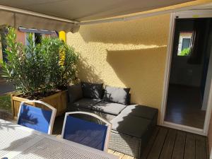 a patio with a couch and chairs on a porch at *Jolie maison proche plage et lac marin, avec piscine, tennis à Soustons Plage* in Soustons