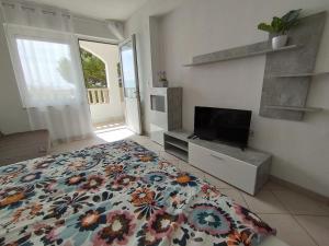 a bedroom with a bed and a tv and a window at Apartments with sea view Drvenik Makarska riviera in Drvenik