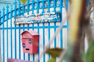 a blue fence with a red mailbox on it at Eco hostel floreale in Ercolano